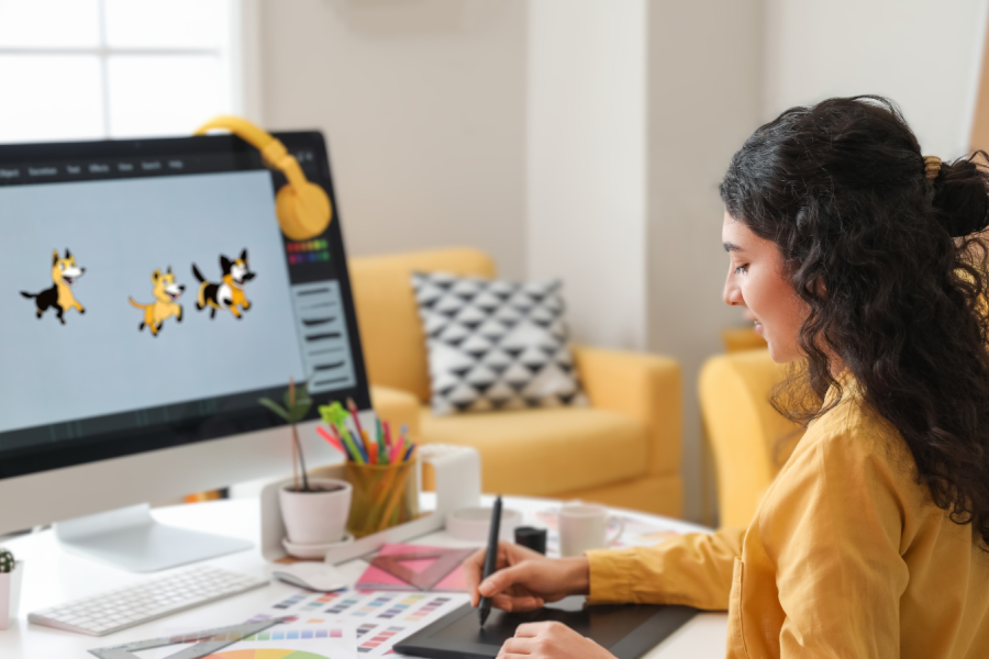 A girl sitting at a desk and drawing on a tablet