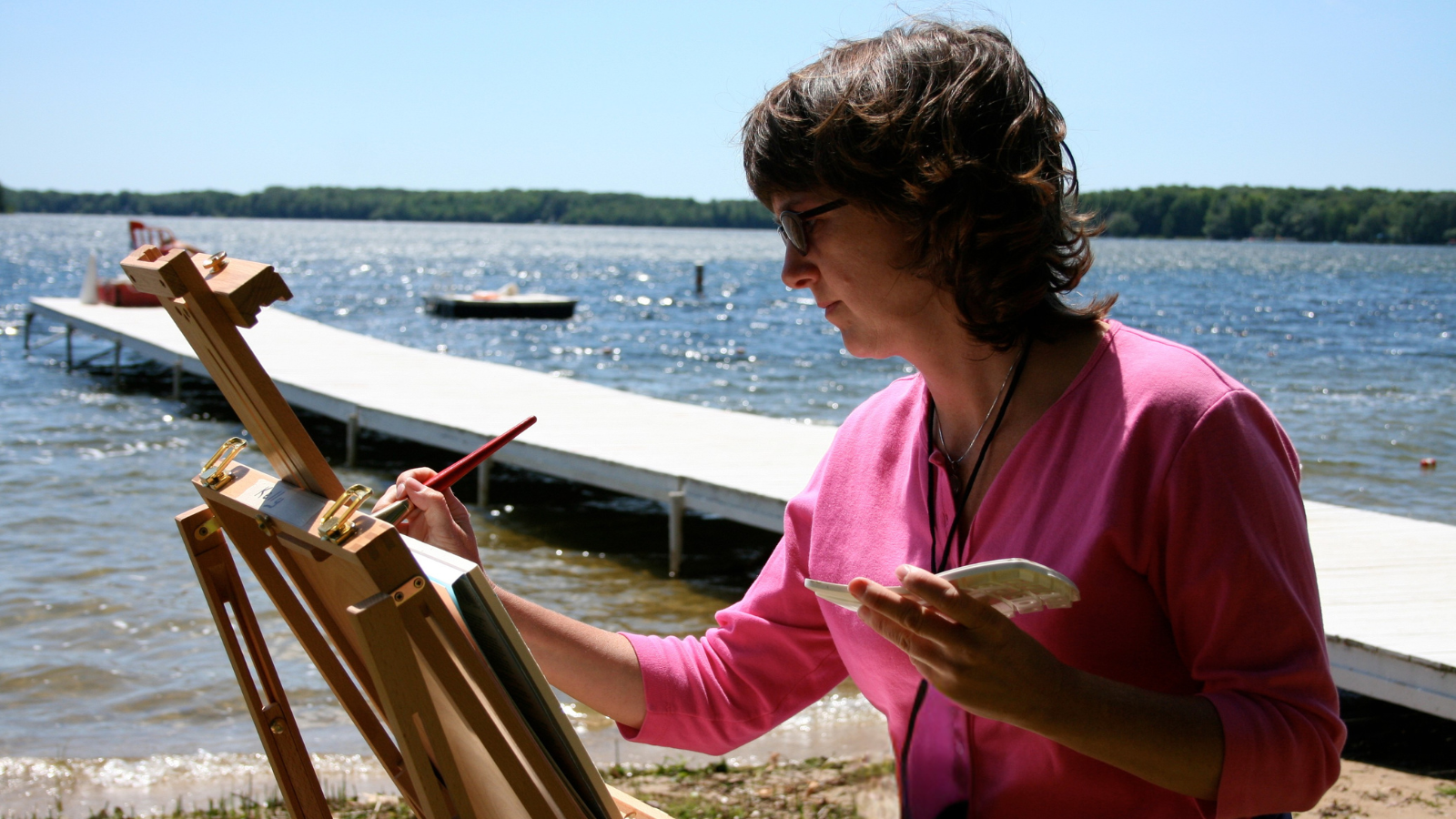 A woman painting near a shoreline