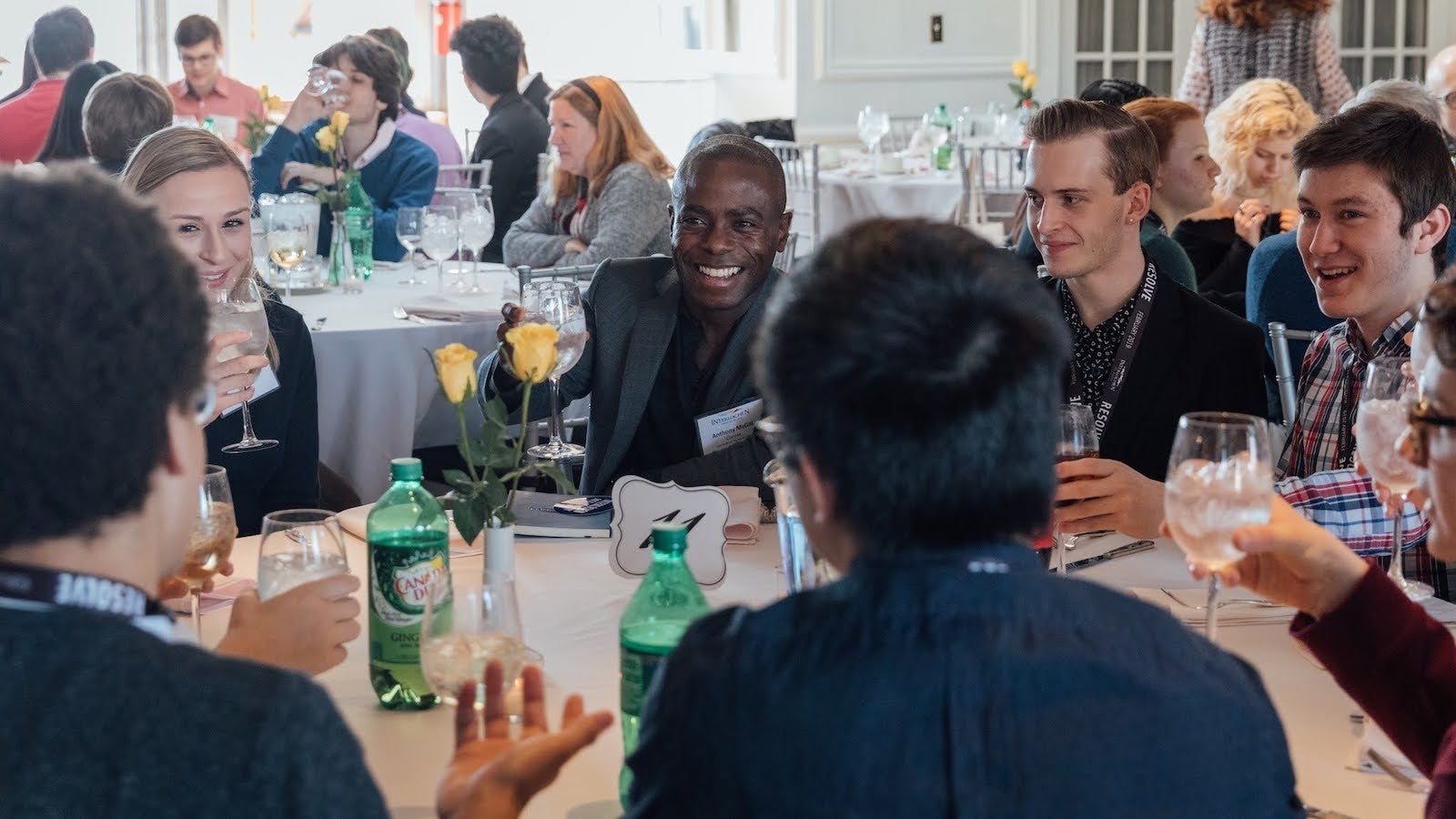  A group of students and alumni at a luncheon, engaged in conversation.