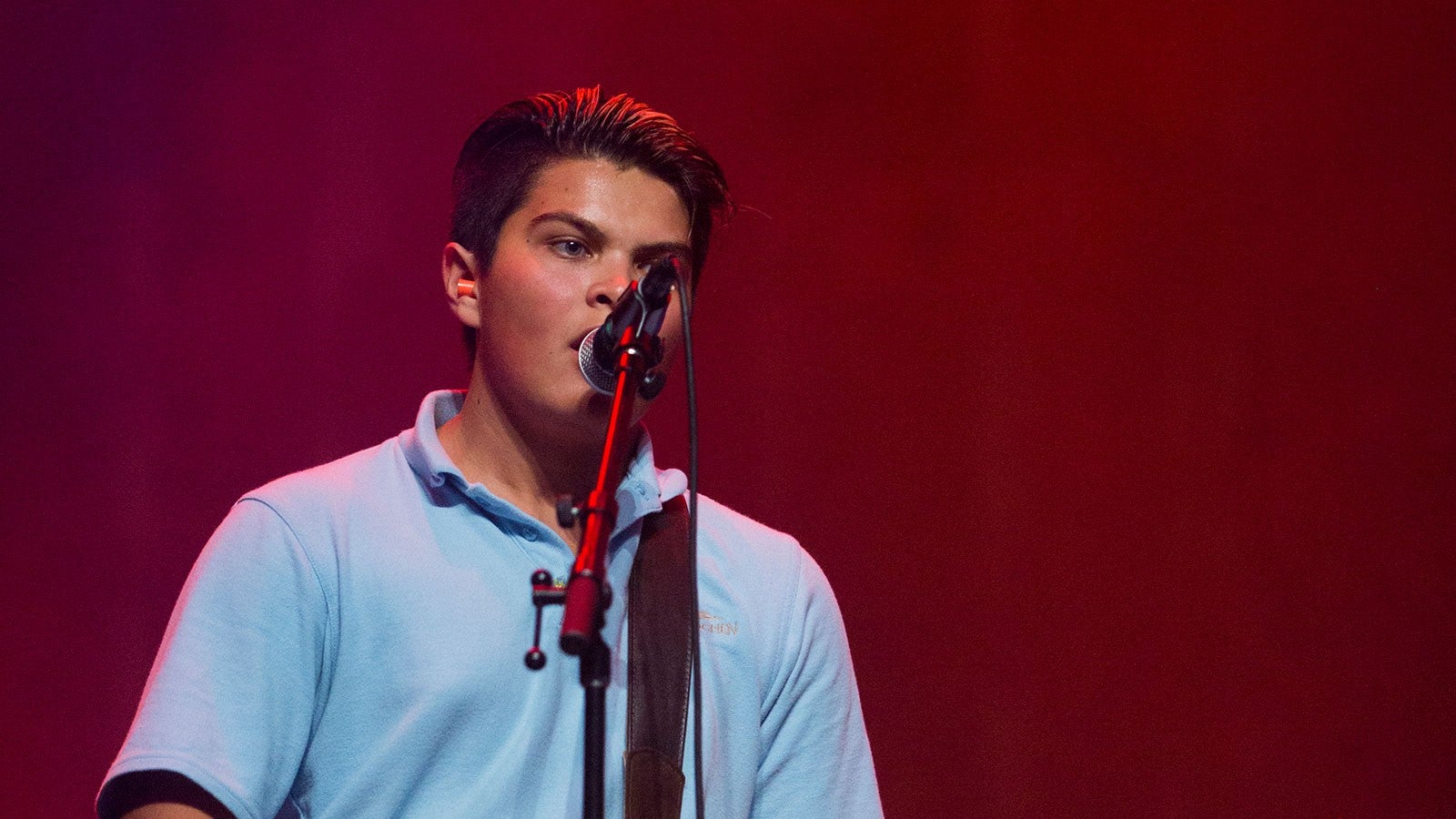 A boy sings into a microphone