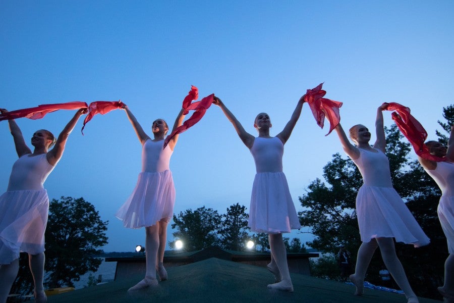 A group of dancers against a twilight sky