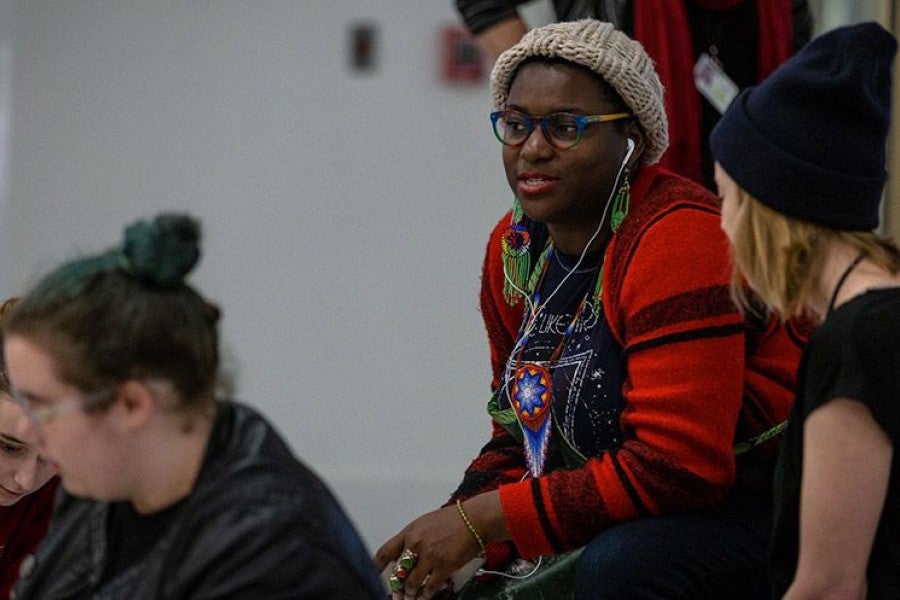 Kenyatta Hinkle (center) chats with Instructor of Visual Arts Megan Hildebrandt (right) while the students work.