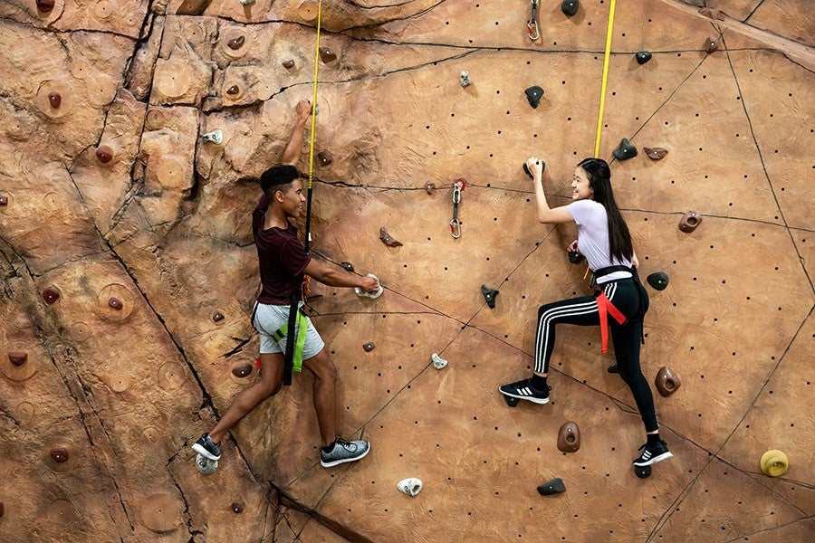 Two Interlochen Arts Academy students scale the climbing wall at the Dennison Center