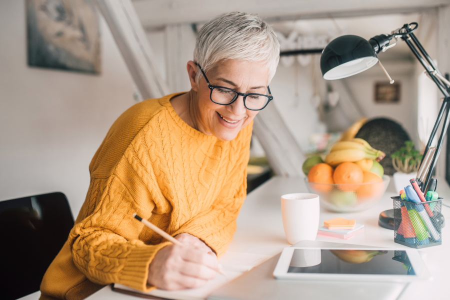 A woman is writing at a desk