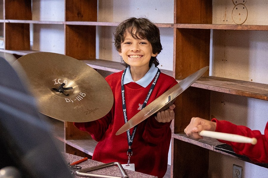 A junior percussion student smiles during a Brass and Percussion Ensemble rehearsal.