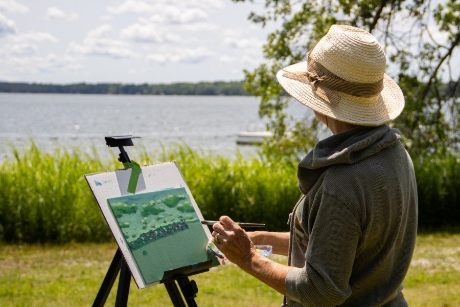 A woman painting near a lake