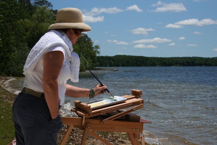 A woman painting on the waterfront