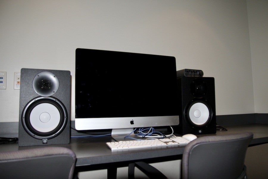 A shot of an edit suite featuring sound monitors and an iMac.