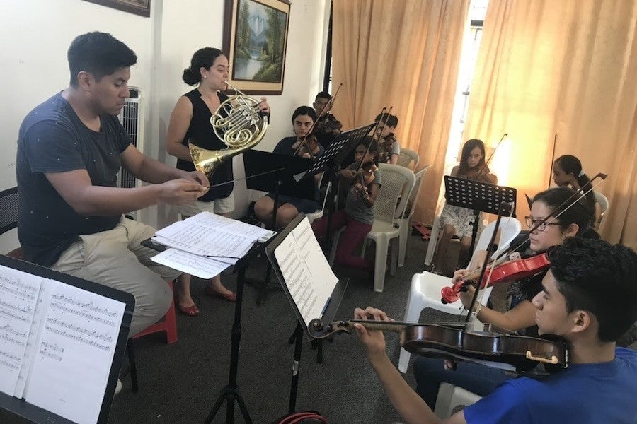 A group of chamber musicians gathers to play inside a house.