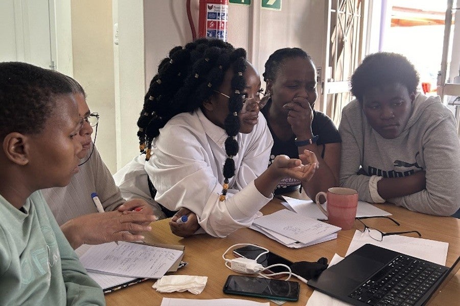 Mwila sits with several survivors in her program.