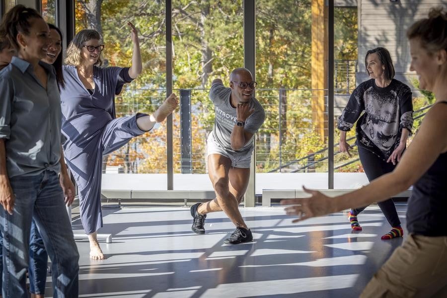 Alumni form various dance movements in a studio.