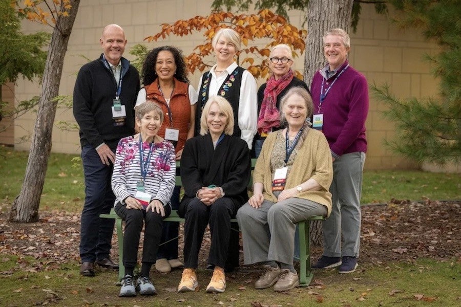 A group of eight smiling people pose.