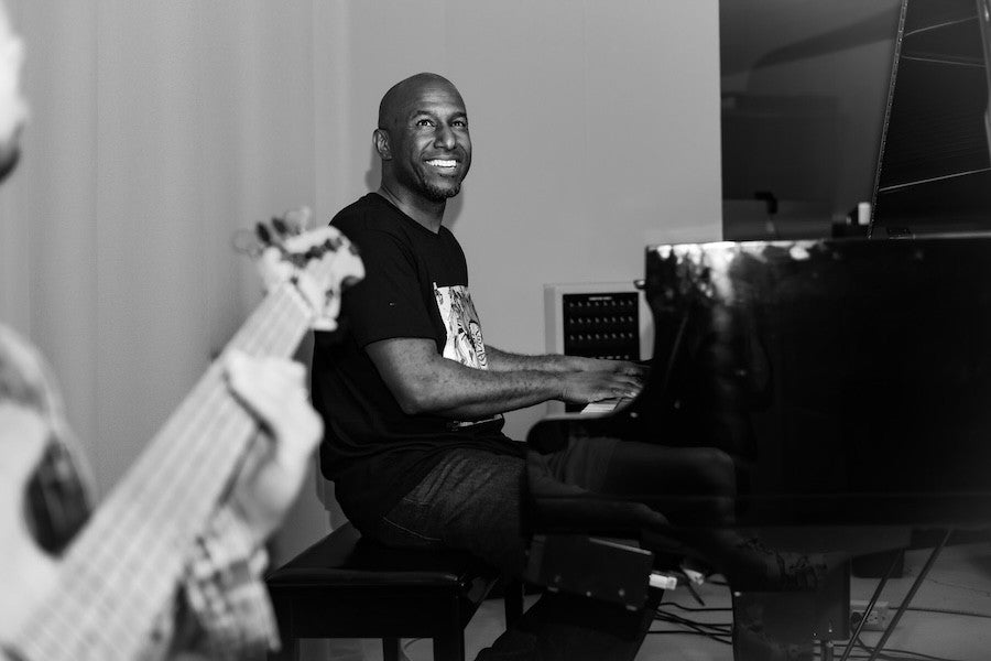 A smiling Levi Taylor plays piano .