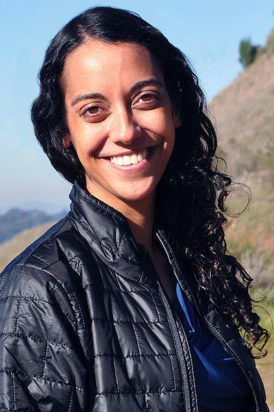 Alumna Sujata Murty smiling while outdoors on a clear, sunny day in the mountains