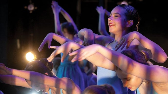 A group of young dancers in blue dresses