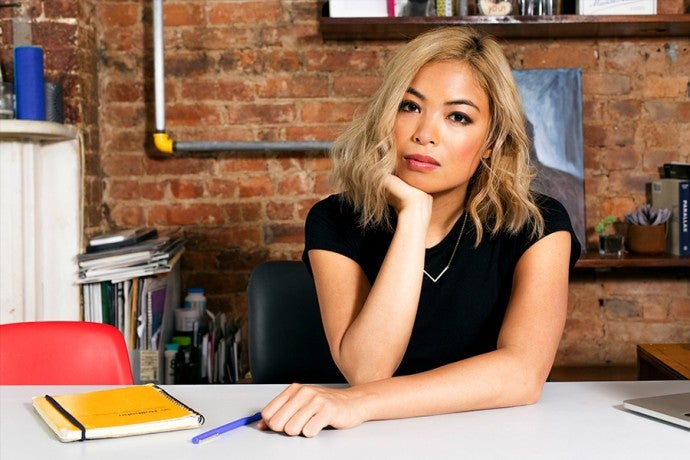 a woman poses at desk