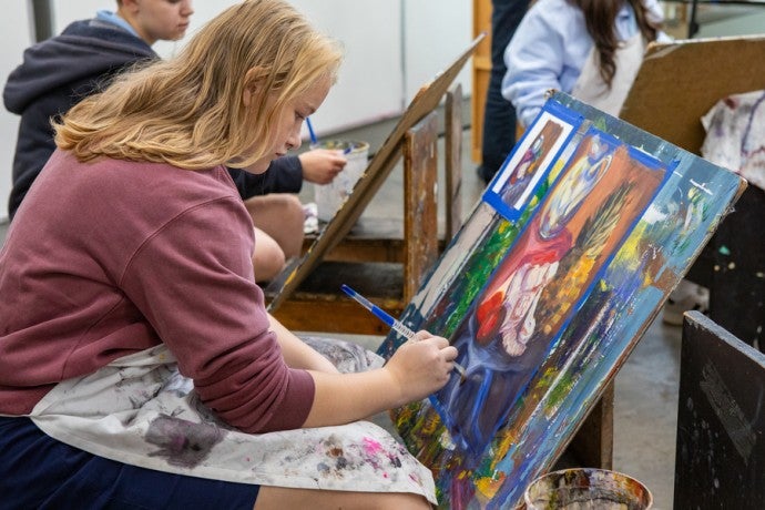 An Interlochen Arts Camp painting student works on canvas. 