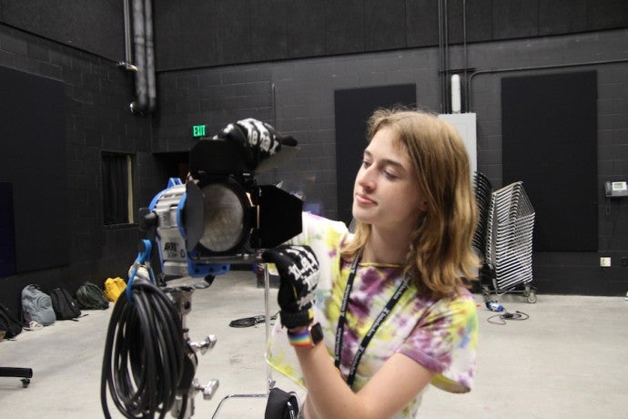 A student adjusts an ARRI light.