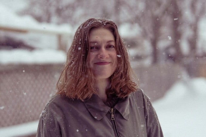 Claire Collins gazes into the camera on a snowy afternoon.