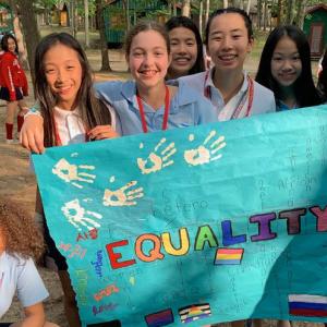 A group of intermediate students with a banner that reads "equality"