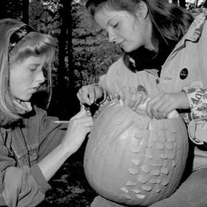 Two students carving pumpkins