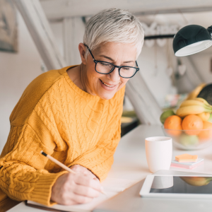 A woman is writing at a desk