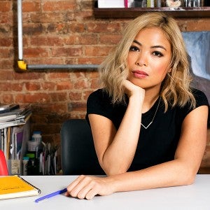 a woman poses at desk