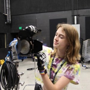 A student adjusts an ARRI light.