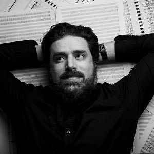 Jeff Toyne poses on top of a background of musical scores