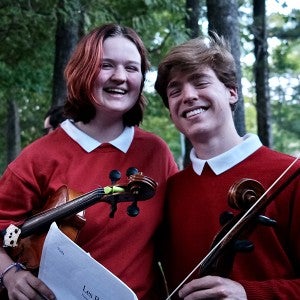 Two students share a smile before the summer 2023 performance of "Les Préludes."