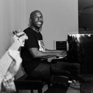 A smiling Levi Taylor plays piano .