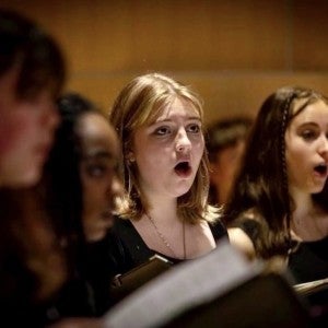 A group of choir students sing.