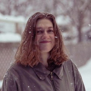 Claire Collins gazes into the camera on a snowy afternoon.